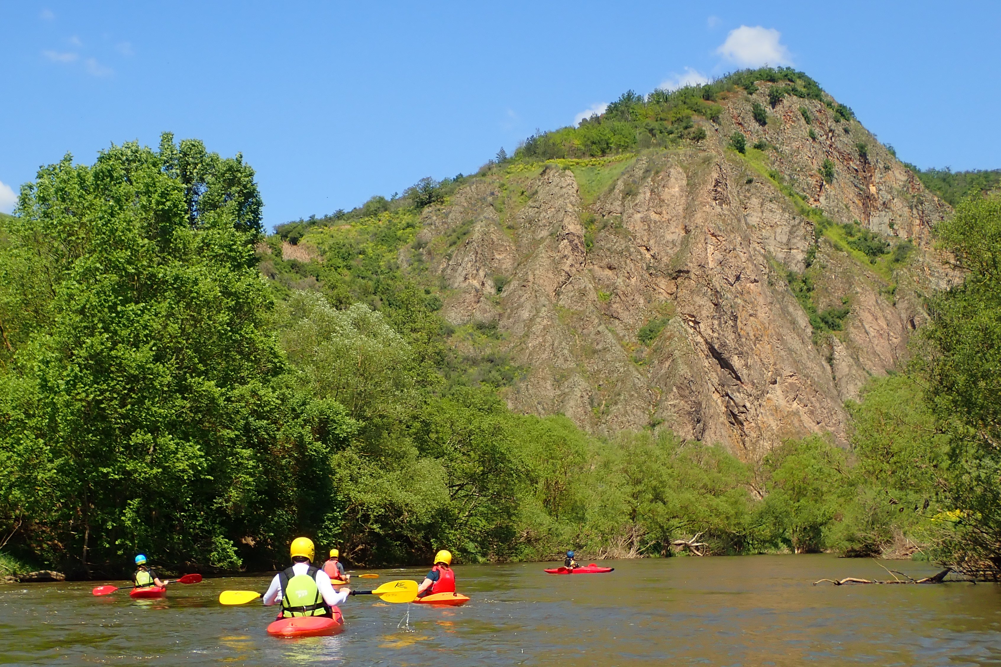Langsam Paddelt man auf der Nahe in bewaldeter Umgebung an einem Rotenfelsmassiv vorbei