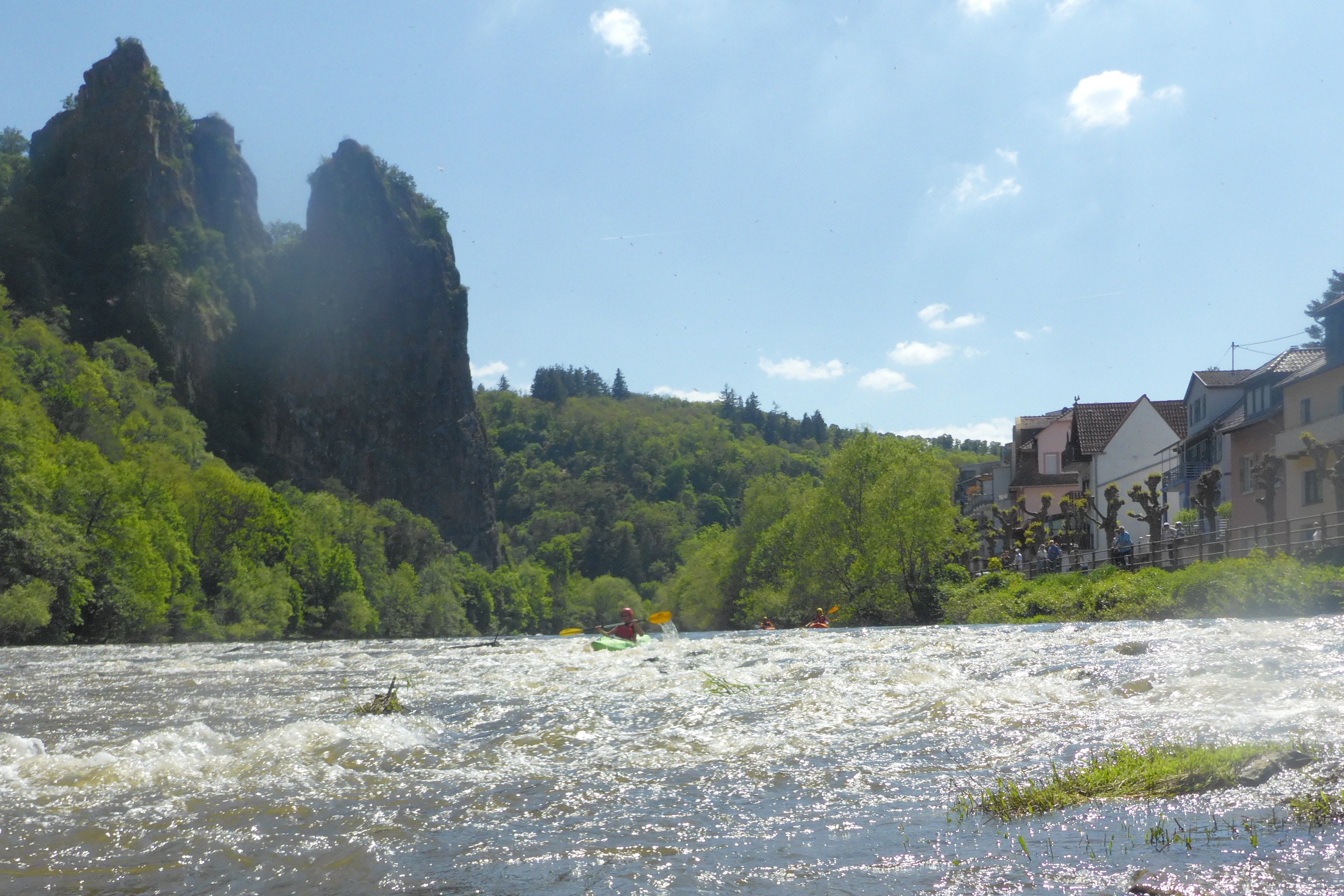Am Ende einer Stromschnelle sichert ein Boot die ankommenden Paddler