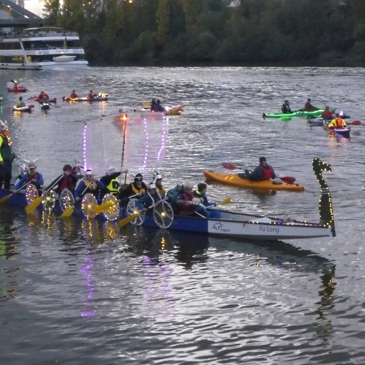 Das mit Lichter besitzen „Wikingerschiff“ mit ihrer verkleideten Mannschaft mit 6 Paddler und ein Ruderer noch im Hellen am Rudererdorf